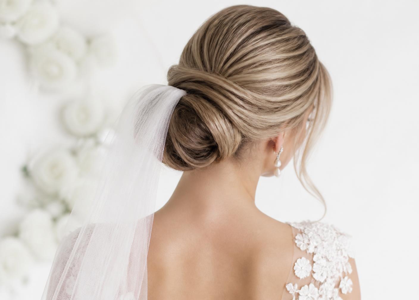 Bridal low chignon updo with a soft veil, seen from behind